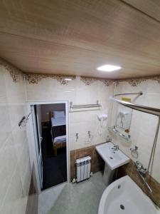 a bathroom with a toilet and a sink and a bed at Bukhara Hotel Alikhan in Bukhara +41 photos