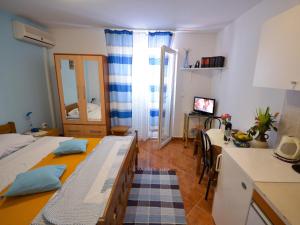 ein Schlafzimmer mit 2 Betten und eine Küche mit einem Tisch in der Unterkunft Villa Nada in Zadar
