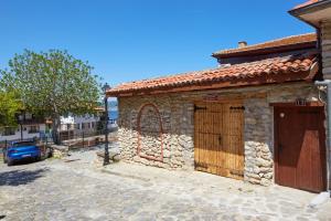 a stone building with a gate on a street at ВИЛА ТЪРТЕФФ in Nesebar