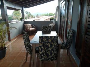 Pokój ze stołem i krzesłami na balkonie w obiekcie Hostel Lê Castelle w mieście Caraguatatuba