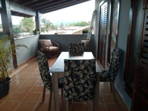 a room with a table and chairs on a balcony at Hostel Lê Castelle in Caraguatatuba