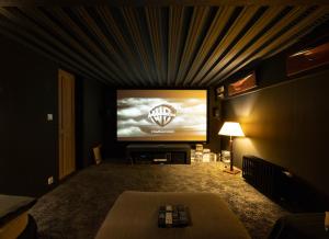 a living room with a large screen television at VILLA LE LOFT - CALME & DECO - Patio intime - Salle de Cinéma - Centre Ville in Vannes
