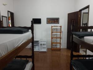 Pokój z 2 łóżkami piętrowymi i telewizorem w obiekcie Hostel Lê Castelle w mieście Caraguatatuba