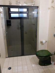 W łazience znajduje się prysznic i zielona toaleta. w obiekcie Hostel Lê Castelle w mieście Caraguatatuba