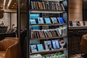 Taiwan Youth Hostel & Capsule Hotel في تايبيه: رف كتاب مليء بالكتب في مكتبة