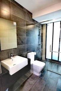 a bathroom with a white toilet and a sink at Almas Muji Studio 100mbps Netflix STAY in Nusajaya