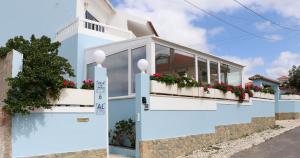 a blue and white house with flowers on the balcony at Villa da Praia in Sintra