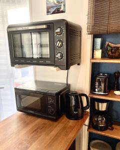 a microwave sitting on top of a counter at Appartement Haute Ville meublé avec cour privative in Granville