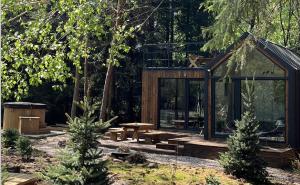 a cabin in the middle of a forest with trees at Odpoczynek Domki Pod Dębem z Opcją Jacuzzi in Ćmińsk