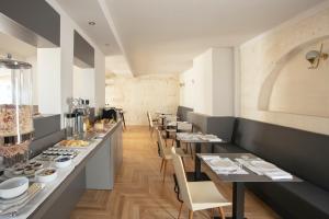 una sala da pranzo con tavoli e sedie lunghi di Palazzo dei Tolomei a Lecce