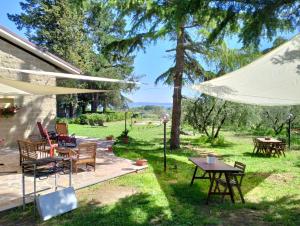 patio ze stołami i krzesłami oraz białym parasolem w obiekcie Agriturismo La Villetta w mieście San Lorenzo Nuovo