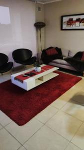 a living room with a couch and a red rug at Laguna Bahía Algarrobo Valparaiso in Algarrobo