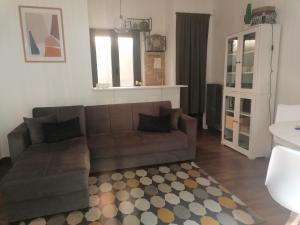 een woonkamer met een bruine bank en een tapijt bij Casa sole in Stresa