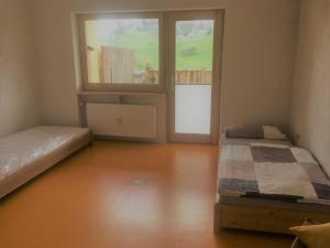 a bedroom with two beds and a large window at Ferienwohnung Fuchsbau in Brombachtal