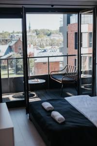 1 dormitorio con 1 cama y balcón con mesa en Arcade - Apartment with a sunny view - A/C en Cracovia