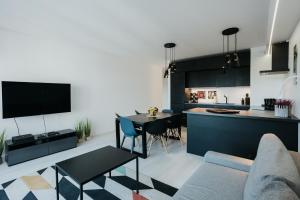 cocina y sala de estar con sofá y mesa en Arcade - Apartment with a sunny view - A/C en Cracovia