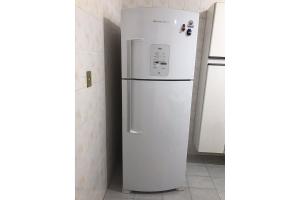 Un refrigerador blanco en una cocina junto a una pared. en T004 - Apto na Tupi com sacada, garagem e ótima localização, en Samaritá