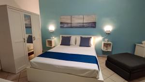 una camera da letto con un grande letto con pareti blu di Blu Salina - Casa Vacanze a Margherita di Savoia