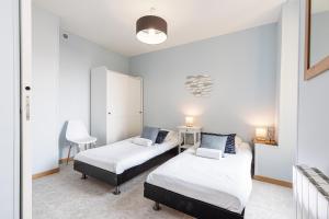 sypialnia z 2 łóżkami i krzesłem w obiekcie Large 3 Bdr City Center w Nicei