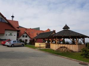 einen Pavillon mit einem Auto neben einem Gebäude in der Unterkunft Ośrodek Wypoczynkowy EDEN Maniowy in Maniowy