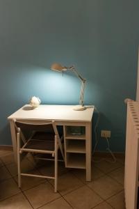 a desk with a lamp on a blue wall at Blu Salina - Casa Vacanze in Margherita di Savoia