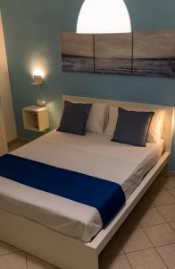 un grande letto in una camera da letto con una luce sopra di essa di Blu Salina - Casa Vacanze a Margherita di Savoia