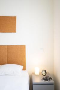 1 dormitorio con 1 cama y mesita de noche con reloj en Monsanto Hill House - NO 571 1E, en Lisboa