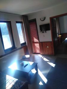 Вила Родопи في دوسبات: غرفة معيشة مع طاولة قهوة ونوافذ