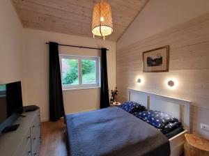 a bedroom with a bed and a tv and a window at Domb ház Visegrád in Visegrád