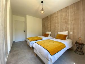 Dos camas en una habitación pequeña con en Villa moderne , neuve piscine jacuzzi ., en Sarlat-la-Canéda 12 fotos más