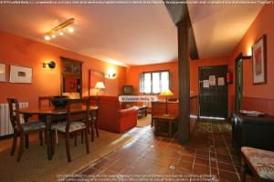 a living room with orange walls and a table and a couch at Apartamentos Buga in Posada