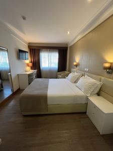 a bedroom with a large white bed and a room at Seculo Hotel in Porto
