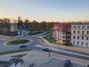 a person crossing a street in a city with cars at Apartament Stanley in Iława