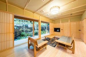 Zimmer mit einem Tisch, Bänken und einem TV in der Unterkunft 高野山 宿坊 恵光院 -Koyasan Syukubo Ekoin Temple- in Koyasan