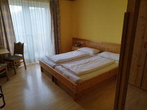 1 dormitorio con 2 camas, silla y ventana en Gasthof Mohr, en Zweiersdorf