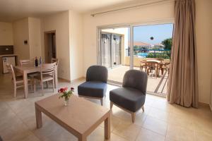 a living room with a table and chairs and a balcony at Makronisos Village in Ayia Napa