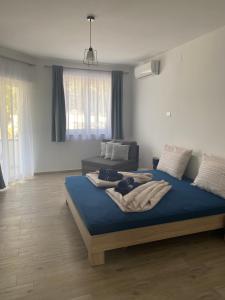 a bedroom with a bed with blue sheets and a couch at Villa Mara in Pula