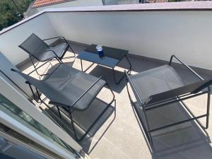 three chairs and a table on a balcony at Villa Mara in Pula