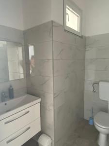 a white bathroom with a toilet and a sink at Villa Mara in Pula