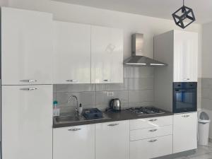 a white kitchen with white cabinets and a sink at Villa Mara in Pula