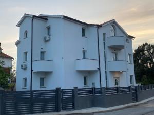 a white building with a fence in front of it at Villa Mara in Pula