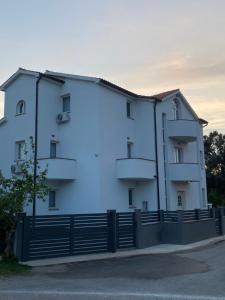 a white building with a fence in front of it at Villa Mara in Pula