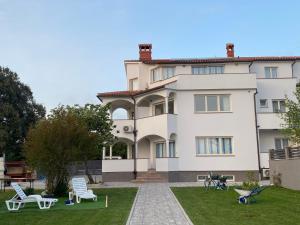 a large white building with a yard with chairs at Villa Mara in Pula