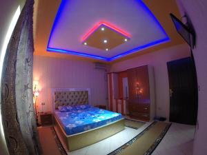 1 dormitorio con 1 cama con luz azul en Hotel Buza, en Shkodër
