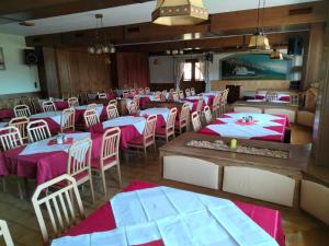 uma sala de jantar com mesas e cadeiras cor-de-rosa e brancas em Gasthof Mohr em Zweiersdorf