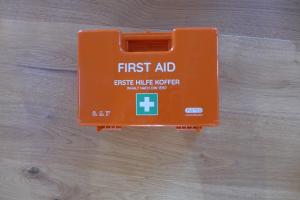 an orange first aid box on a wooden floor at Ferienwohnung Birkennest in Bad Heilbrunn