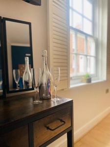 een tafel met twee wijnglazen en een spiegel bij Beverley Snug in Beverley