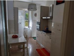 a kitchen with white cabinets and a table and a window at A due passi dal mare in Sori