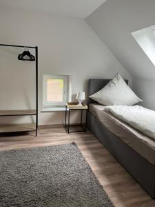 a bedroom with a bed and a table and a window at Haus am Deich in Butjadingen