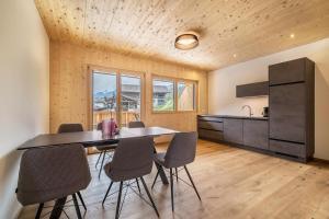 Una cocina y un comedor con mesa y sillas. en Naturapartments Alpreid Fichte, en San Pancrazio